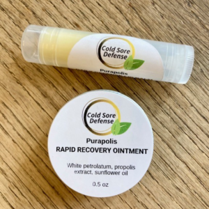 Purapolis Cold Sore Defense Complete Relief Duo with Daily Defense Lip Balm and Rapid Recovery Ointment made with bee propolis, on a wooden table.